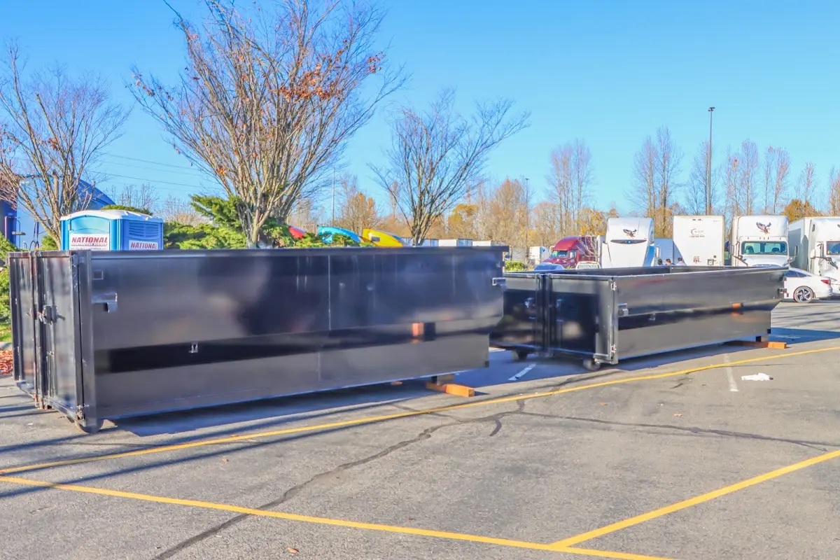 Professional dumpster rental service with roll-off container on residential driveway in East Bradford